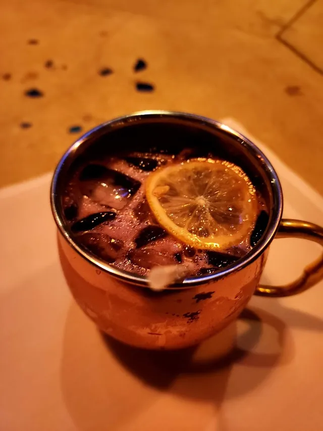 Cocktail in a copper mug garnished with citrus