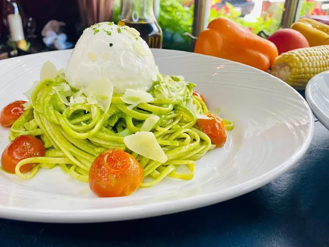 Green pasta with cherry tomatoes and a creamy white topping